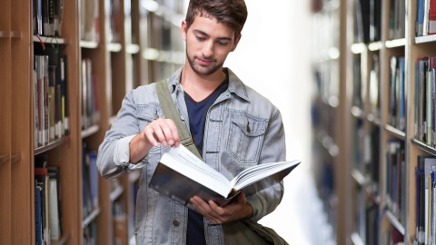 Un estudiante consulta un libro en la biblioteca. Foto: Pixabay