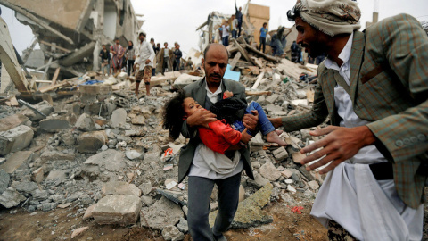 Un hombre lleva en brazos a una niña herida en un bombardeo de la coalición saudí contra Yemen en agosto de 2017. Khaled Abdullah / REUTERS