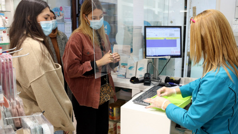 Diverses noies esperant el torn per fer-se un test d'antígens en una farmàcia.