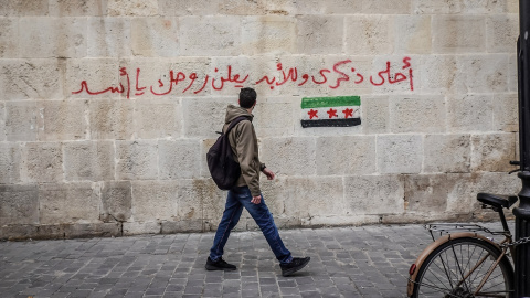 Un hombre camina por una calle de Damasco en Siria. En la pared puede leerse: "Maldito seas para siempre, Assad". Imagen de archivo. Un hombre camina por una calle de Damasco en Siria. En la pared puede leerse: "Maldito seas para siempre, Assad". Imagen de archivo.