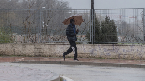 Una persona se protege de la lluvia en Alcalá de Henares, a 19 de enero de 2024. Una persona se protege de la lluvia en Alcalá de Henares, a 19 de enero de 2024.