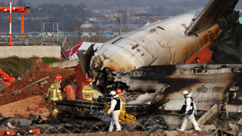 Bomberos trabajan entre los restos del avión de Jeju Air en el aeropuerto de Muan, Corea del Sur. Bomberos trabajan entre los restos del avión de Jeju Air en el aeropuerto de Muan, Corea del Sur.