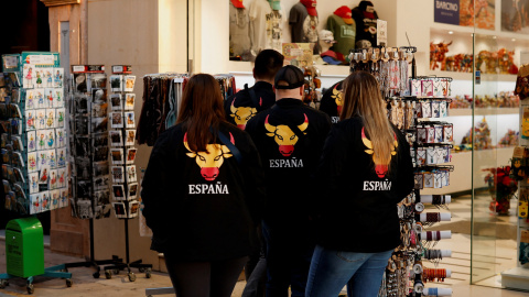 Un grupo de turistas, con sudaderas con una imagen de un toro con los colores de la bandera española, en una tienda de souvenirs, en la localidad malagueña de Rondas. Un grupo de turistas, con sudaderas con una imagen de un toro con los colores de la bandera española, en una tienda de souvenirs, en la localidad malagueña de Rondas.