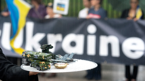 Un activista sostiene objetos que representan la venta de armas en Estados Unidos durante una manifestación frente a la Casa Blanca en Washington, (Estados Unidos).