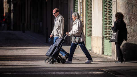 Dues persones grans passejant per un carrer de Barcelona Dues persones grans passejant per un carrer de Barcelona