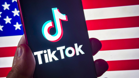 EuropaPress_6463465_18_january_2025_us_____social_media_app_tiktok_logo_pictured_on_smart_phone El logotipo de la aplicación de redes sociales TikTok aparece en un teléfono inteligente frente a la bandera estadounidense. Imagen de archivo.