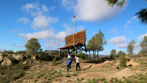 Un grup d'homes sostè el descens del banc gegant al mirador de Vall de Porcs de Riba-roja d'Ebre Un grup d'homes sostè el descens del banc gegant al mirador de Vall de Porcs de Riba-roja d'Ebre