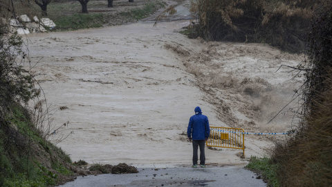 Un hombre junto a la carretera cortada por el desbordamiento del río Argos, Murcia, a 6 de marzo de 2025.