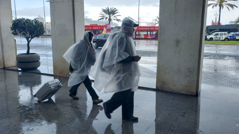 Varias personas se protegen de la lluvia en Cádiz, a 9 de marzo de 2025.