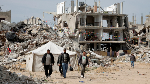 Hombres palestinos caminando cerca de escombros de casas destruidas durante la ofensiva israelí, en Rafah, en el sur de la Franja de Gaza, el 13 de marzo de 2025. Hombres palestinos caminando cerca de escombros de casas destruidas durante la ofensiva israelí, en Rafah, en el sur de la Franja de Gaza, el 13 de marzo de 2025.