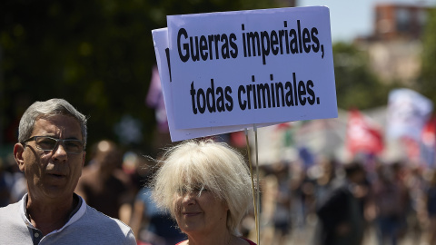 Una mujer sostiene una pancarta contra la guerra, a 26 de junio de 2022, en Madrid.