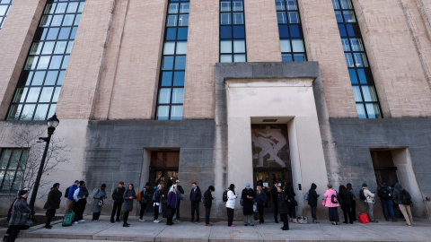 Empleados del Departamento de Salud y Servicios Humanos (HHS, por sus siglas en inglés) hacen cola esperando afuera de su sede, en en el edificio Mary E. Switzer, en Washington