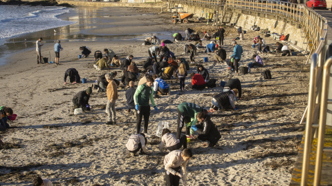 Imagen de archivo de arios voluntarios recogen pellets en la playa de Panxón, en Galicia. Imagen de archivo de arios voluntarios recogen pellets en la playa de Panxón, en Galicia.