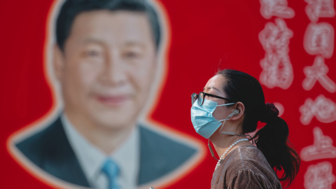 Una mujer camina frente a un retrato del presidente chino Xi Jinping en Shanghái, China, el 1 de abril de 2025.