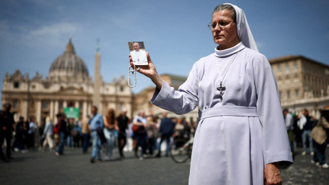 Papa REUTERS Una monja sostiene una imagen del Papa Francisco cerca de la plaza de San Pedro este lunes 21 de abril de 2025.