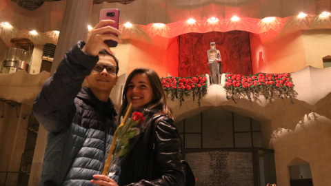 Una parella fent-se una foto al davant del Sant Jordi de la Sagrada Família amb la rosa i el llibre que els han donat abans de la visita guiada Una parella fent-se una foto al davant del Sant Jordi de la Sagrada Família amb la rosa i el llibre que els han donat abans de la visita guiada