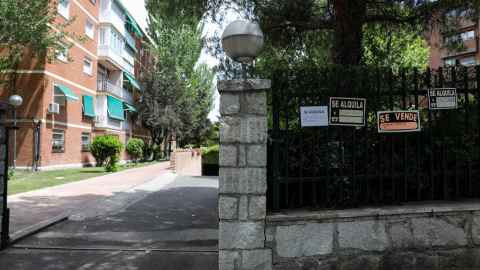 Foto de archivo de una valla de una urbanización con varios carteles.