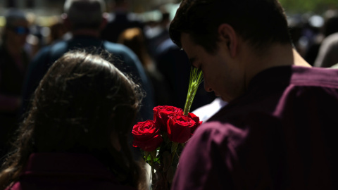 Una pareja con varias rosas camina por el centro de Barcelona durante la Diada de Sant Jordi.