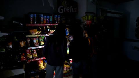 apagondirecto Varios clientes e iluminan con el móvil en un supermercado del centro de Barcelona durante eel histórico apagón que ha vivido España este lunes.