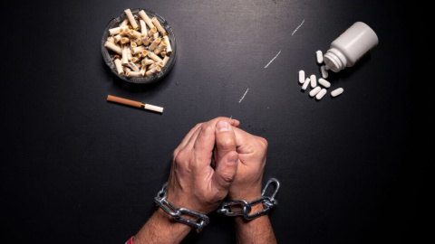 nuevas-drogas-tendencias-consumo-apoyo-adicciones-salud-mental-prevencion-recuperacion-apoyo-familiar-recuperacion-educacion-drogas-conciencia-REMAR-ONG-familia-980x551 Unas manos con esposas junto a un cenicero y un bote de pastillas.