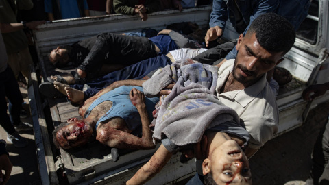 Un hombre saca de una camioneta el cadáver de un niño asesinado por Israel en un bombardeo sobre un restaurante y un mercado que el pasado miércoles costó la vida a 25 personas en Gaza.