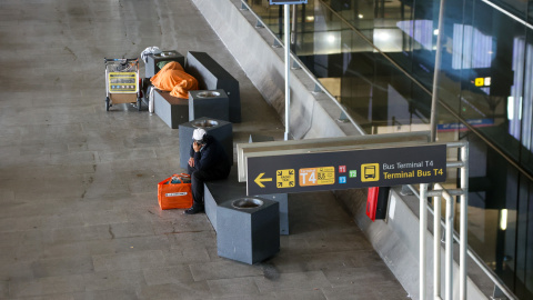 Imagen de dos personas sin hogar en la Terminal 4 de Barajas.