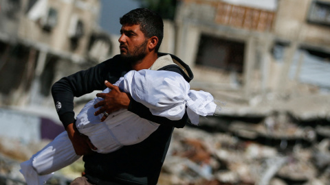 Un hombre palestino lleva el cuerpo de un niño muerto en ataques israelíes en Jabalia, en el norte de la Franja de Gaza