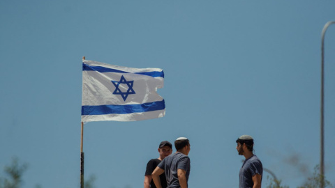 Colonos judíos izan banderas israelíes en viviendas palestinas en la aldea de Bruqin, en el norte de Cisjordania, a 23 de mayo de 2025. (Foto de