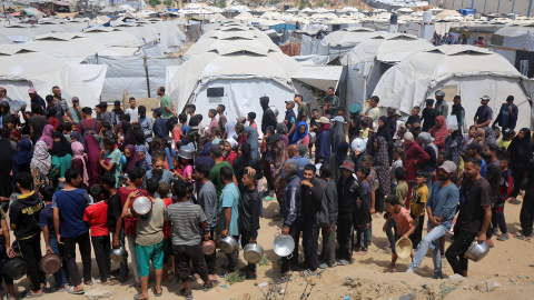 Palestinos hacen cola para recibir comida caliente distribuida por las organizaciones humanitarias, a 28 de mayo de 2025.