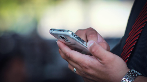 Foto de archivo de una persona con un teléfono móvil.