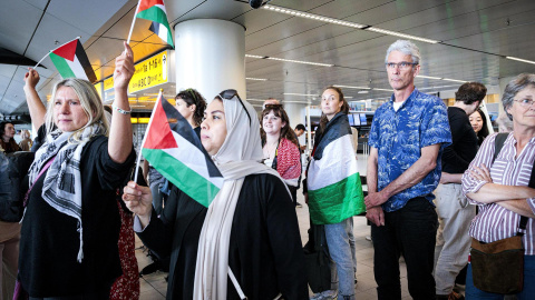 La gente ondea banderas palestinas mientras los participantes de la "Marcha Global a Gaza" parten del aeropuerto de Schiphol hacia Egipto en Schiphol, Países Bajos, el 11 de junio de 2025.