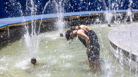 Unos jóvenes se refrescan en una fuente en Logroño el pasado viernes  de las obras de Concéntrico, ?Monumental Splash, ?que transforma por unos días la Fuente de Espartero en un oasis urbano compartido, invitando a los ciudadanos a refrescarse y a repensar el papel de los monumentos y del agua como elementos clave para enfrentar el calor extremo y el cambio climático. La Dirección General de Salud Pública, Consumo y Cuidados del Gobierno de La Rioja ha activado el nivel 2 (naranja) del 'Plan de alerta, prevención y control de los efectos del calor.-EFE/Raquel Manzanares