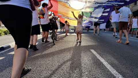 Dues nenes juguen sota una bandera multicolor durant el Pride Barcelona Dues nenes juguen sota una bandera multicolor durant el Pride Barcelona