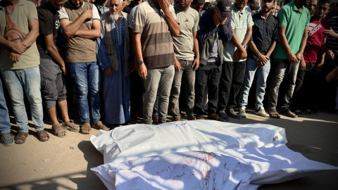 Varias personas rezan junto a los cadáveres de los fallecidos tras un bombardeo el pasado viernes sobre Jan Yunis, al sur de Gaza. Varias personas rezan junto a los cadáveres de los fallecidos tras un bombardeo el pasado viernes sobre Jan Yunis, al sur de Gaza.
