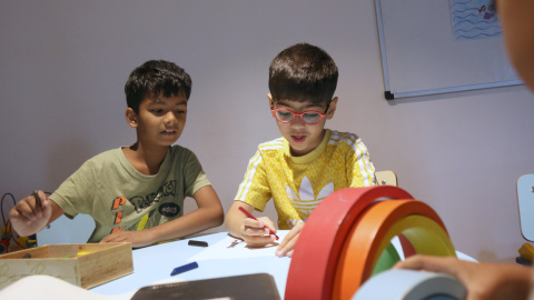 Un infant fill d'una família monoparental dibuixant en un casal per a infants vulnerables que Càritas ofereix a Barcelona