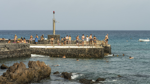 06fc3863de16a69efb77d6e5411986b05f8d08d6 Varios bañistas se refrescan este martes en el muelle de Punta Mujeres, en Lanzarote.