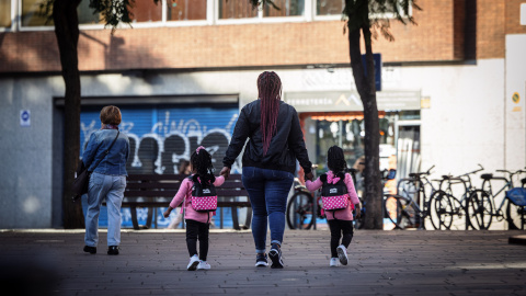 Una dona amb dues criatures en un carrer de Barcelona Una dona amb dues criatures en un carrer de Barcelona