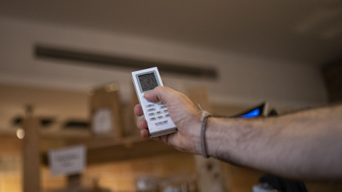 Una persona enciende un aparato de aire acondicionado. Foto de archivo. Una persona enciende un aparato de aire acondicionado. Foto de archivo.