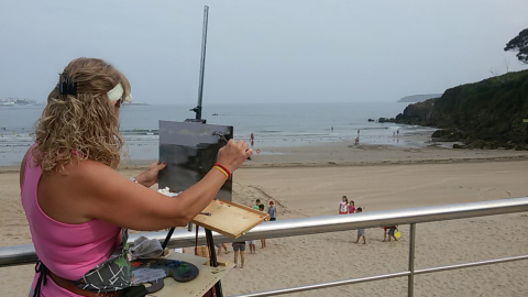 Una mujer pinta un cuadro en un playa de Oleiros (A Coruña). Una mujer pinta un cuadro en un playa de Oleiros (A Coruña).
