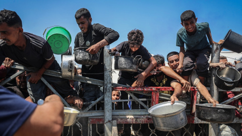 Palestinos esperan una comida distribuida por una organización benéfica.