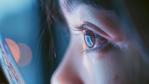 Una niña mira una pantalla de un dispositivo electrónico.