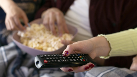 mejores-amigos-viendo-servicio-de-streaming-juntos-en-interiores Ver una película en casa es uno de los planes que triunfan en verano.