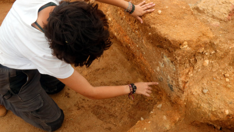 Una arqueòloga assenyalant les restes de pintura mural que s'han trobat en una casa grega del segle V aC de la Neàpolis