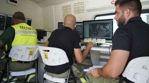Técnicos de extinción, en el puesto de mando del operativo que lucha contra el incendio declarado en la localidad de Caminomorisco, en Las Hurdes cacereñas.