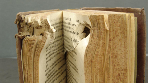 Ejemplar del archivo de la Biblioteca Histórica con la huella del recorrido de una bala de la Guerra Civil.