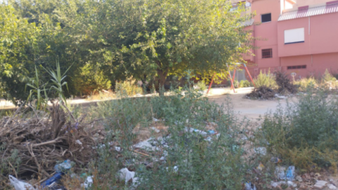 Un parque en El Raval, con suciedad, barro solidificado y los columpios inservibles.