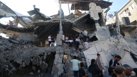 Palestinos entre ruinas en Al Nuseirat en la Franja de Gaza.