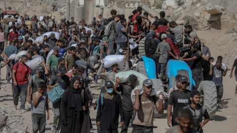 Palestinos transportan suministros de ayuda que ingresaron a Gaza a través de Israel, en Beit Lahia, en el norte de la Franja de Gaza, el 5 de agosto de 2025.