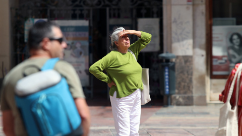 Viandantes soportan las altas temperaturas por las calles de Málaga.