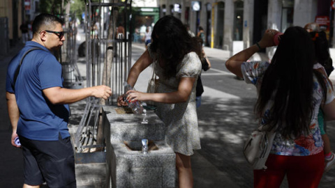 b8d0a59d69b986d6ffcc83412efda7b2dd686bafm Turistas rellenan botellas con agua de una fuente en Madrid.